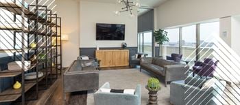 A living room with a grey couch and a wooden cabinet.